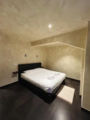 a small bedroom with a bed with white sheets at Fiori private wellness en hotel in Lier