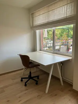 a white desk and a chair in a room with a window at RS10 One-Bedroom Apartment in Turnhout