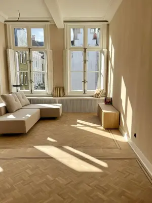 a living room with a couch and two windows at Stylish apartment in 16th century city palace! in Antwerp