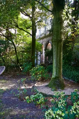 a tree in the middle of a garden with a building at Stylish apartment in 16th century city palace! in Antwerp