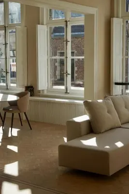 a living room with a couch and a table and windows at Stylish apartment in 16th century city palace! in Antwerp