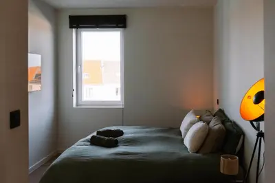 a bedroom with a bed with a teddy bear on it at La Petite Foret Stylish City Apartment Ghent in Ghent