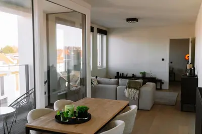 a living room with a table and a couch at La Petite Foret Stylish City Apartment Ghent in Ghent