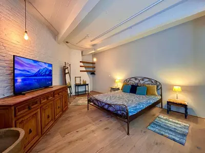 a bedroom with a bed and a flat screen tv at The Vintage Warehouse Room in Antwerp