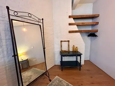 a mirror in a room with a table and a staircase at The Vintage Warehouse Room in Antwerp