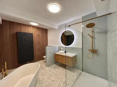 a bathroom with a tub and a sink and a mirror at The Vintage Warehouse Room in Antwerp