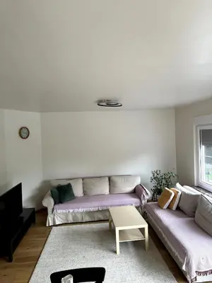 a living room with two couches and a table at Cozy&Spacious apartment with garden in Antwerp