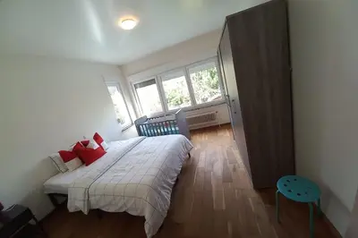 a bedroom with a large bed with red pillows at Cozy&Spacious apartment with garden in Antwerp