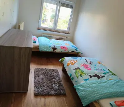 a room with a bed and a desk and a window at Cozy&Spacious apartment with garden in Antwerp