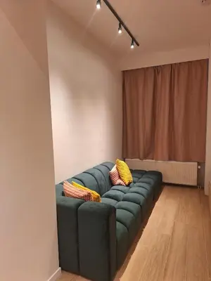 a living room with a green couch with yellow pillows at Funky Jungle house - Rustig gelegen rijwoning in hartje Mechelen in Mechelen