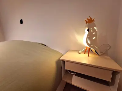 a lamp on a night stand next to a bed at Funky Jungle house - Rustig gelegen rijwoning in hartje Mechelen in Mechelen