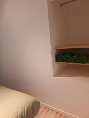 a bedroom with green towels on a shelf at Funky Jungle house - Rustig gelegen rijwoning in hartje Mechelen in Mechelen