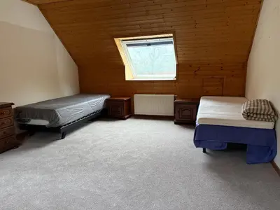 a attic room with two beds and a window at zandhoven vila in Zandhoven