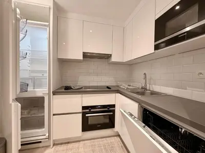 a kitchen with white cabinets and a sink and an oven at Louise in Mellet