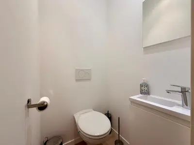 a white bathroom with a toilet and a sink at Louise in Mellet