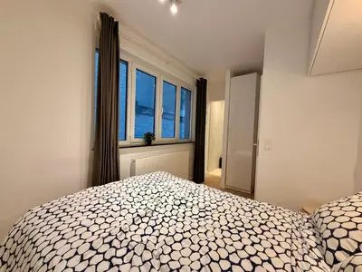 a bedroom with a bed and a large window at Louise in Mellet