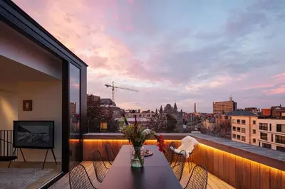 a balcony with a table and a view of a city at Design penthouse800Y of history in one glimpse in Ghent
