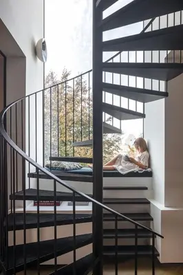 a woman sitting on a bed on a spiral staircase at Design penthouse800Y of history in one glimpse in Ghent