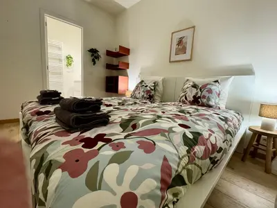 a bedroom with a bed with a floral bedspread at The Twin Suites Apartment in Brussels