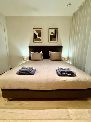 a bedroom with a large bed with two towels on it at The Twin Suites Apartment in Brussels
