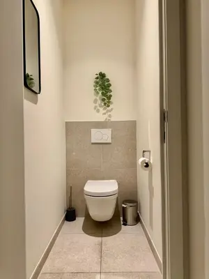 a bathroom with a toilet with a plant on the wall at The Twin Suites Apartment in Brussels