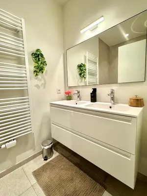 a white bathroom with a sink and a mirror at The Twin Suites Apartment in Brussels