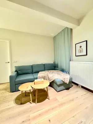 a living room with a blue couch and a table at The Twin Suites Apartment in Brussels