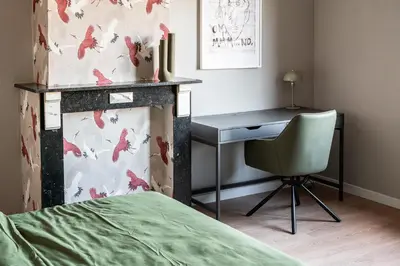 a bedroom with a desk and a bed and a chair at Spacious 5-room house near Brussels with private parking in Steenokkerzeel