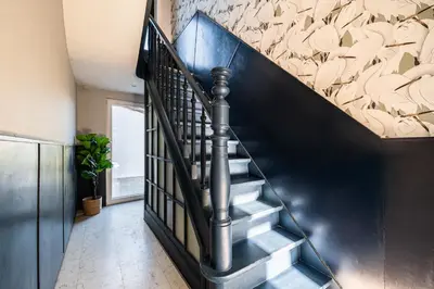 a staircase in a house with a black railing at Spacious 5-room house near Brussels with private parking in Steenokkerzeel