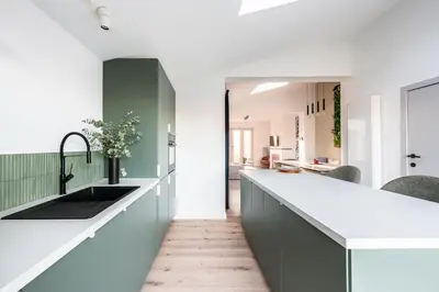 a kitchen with a long counter and a sink at Spacious 5-room house near Brussels with private parking in Steenokkerzeel