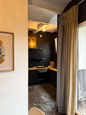 a kitchen with black counters and a curtain in a room at NEW Luna residences - in the city center in Antwerp