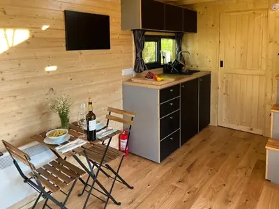 a kitchen with a table and chairs and a refrigerator at Liberty Lodge X by Tiny Away in Kalmthout