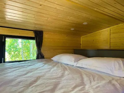 a bed with two pillows in a room with a window at Liberty Lodge X by Tiny Away in Kalmthout