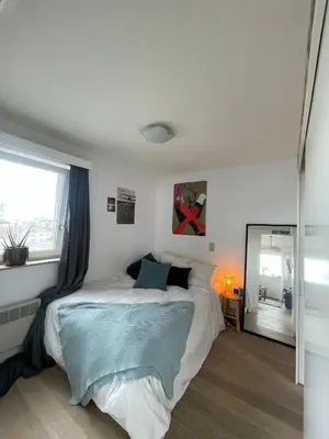 a bedroom with a bed and a window and a mirror at Zalig verblijf in hartje Gent in Ghent
