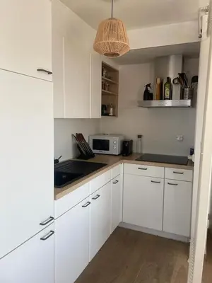 a kitchen with white cabinets and a microwave at Zalig verblijf in hartje Gent in Ghent