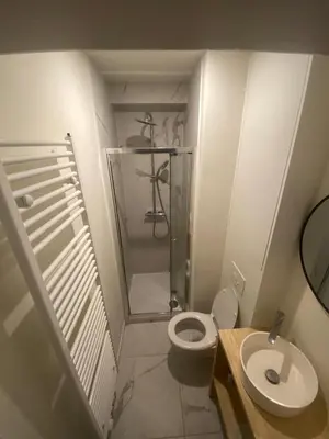 a small bathroom with a toilet and a shower at Cosy Apartment in Antwerp in Antwerp