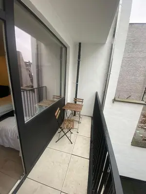 a balcony with a table and chairs on a building at Cosy Apartment in Antwerp in Antwerp