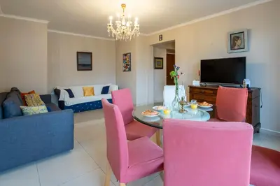 a living room with a table and pink chairs at Brussels Expo Elegant residence in Brussels
