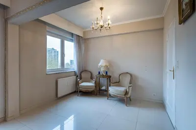 a hallway with two chairs and a table and a window at Brussels Expo Elegant residence in Brussels