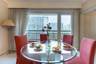 a dining room table with a vase of flowers on it at Brussels Expo Elegant residence in Brussels