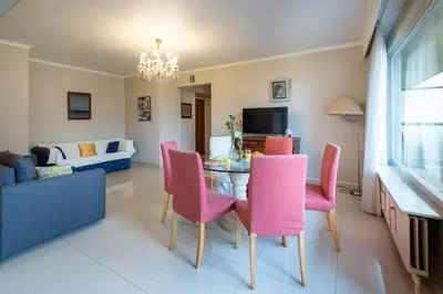 a living room with a table and pink chairs at Brussels Expo Elegant residence in Brussels