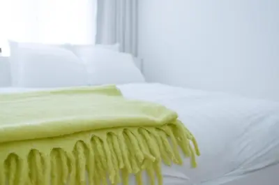 a bed with a green blanket on top of it at Stylish Apartment City Center in Antwerp