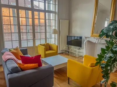 a living room with a couch and chairs and a tv at Un paradis au coeur de Bruxelles in Brussels