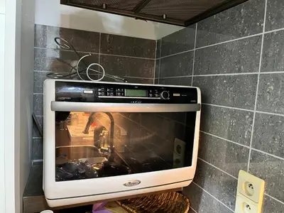 a microwave oven in a kitchen with a wall at Central in Ghent