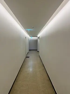 an empty hallway with white walls and a tile floor at Central in Ghent