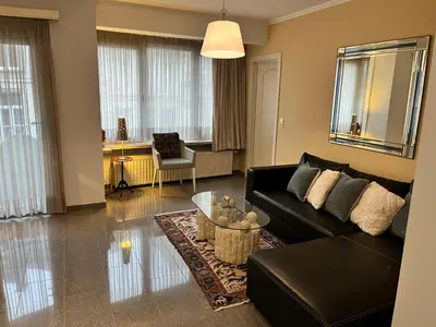 a living room with a black couch and a table at Central in Ghent