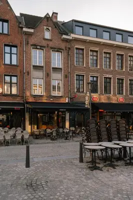 a group of tables and chairs in front of a building at A Place Antwerp - Boutique Suites & Flats - Vrijdagmarkt 18 in Antwerp