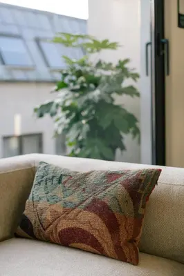 a pillow sitting on the back of a couch at A Place Antwerp - Boutique Suites & Flats - Vrijdagmarkt 18 in Antwerp