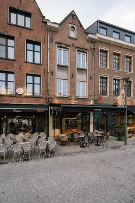 a group of tables and chairs in front of a building at A Place Antwerp - Boutique Suites & Flats - Vrijdagmarkt 18 in Antwerp