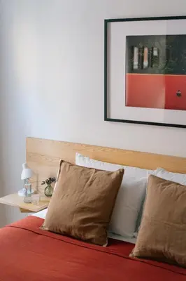 a bed with two pillows and a picture on the wall at A Place Antwerp - Boutique Suites & Flats - Leeuwenstraat 15 in Antwerp